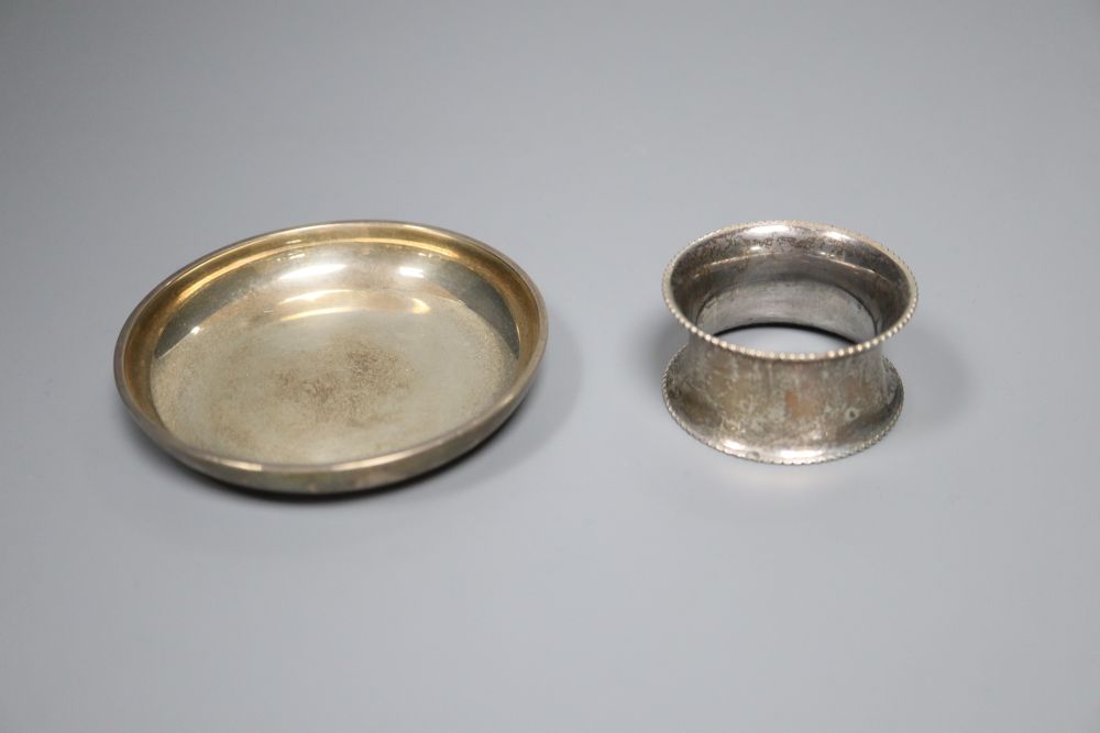 A silver circular ashtray, London, 1932 and a later silver serviette ring, gross 4oz.